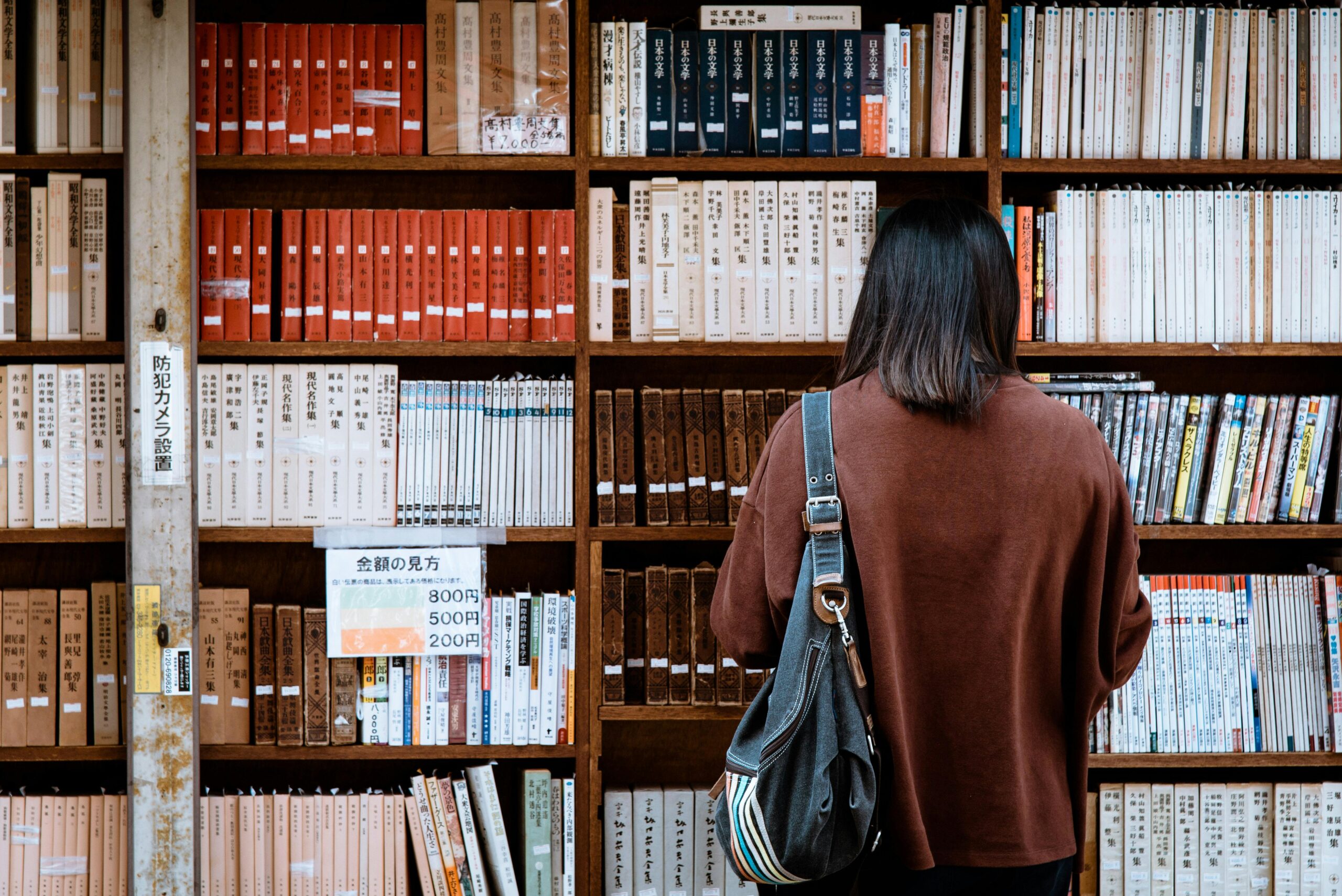 Frau, Die Braunes Hemd TrÃ¤gt, Das Schwarze Ledertasche Auf Der Vorderseite Der BibliotheksbÃ¼cher TrÃ¤gt